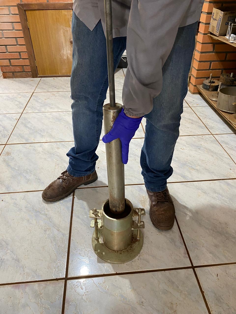 Ensaio de compactação tipo Proctor em laboratório, com corpo de prova sendo compactado em molde metálico padrão